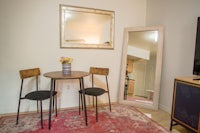 a table and chairs in a room with a mirror