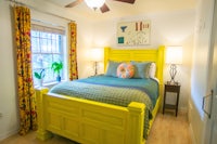 a bed in a bedroom with a yellow headboard